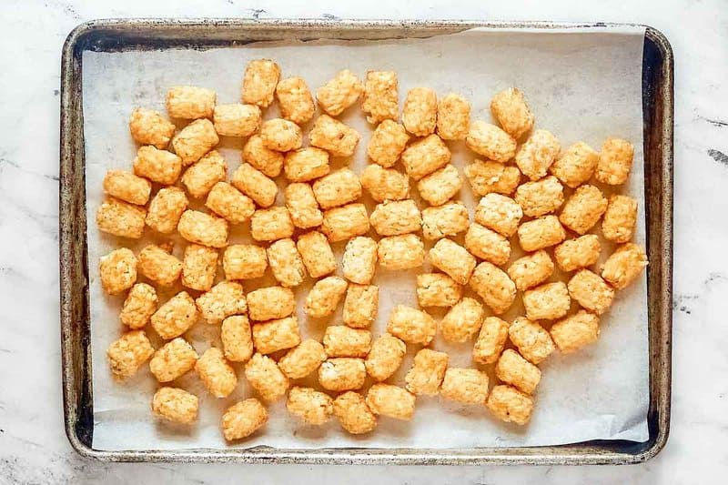 Frozen tater tots on a baking sheet.