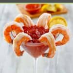 Homemade cocktail sauce served in a martini glass with shrimp.
