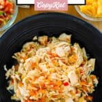 A bowl of Instant Pot salsa chicken, cheese, sour cream, and pico de gallo.