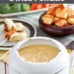 Homemade melting pot traditional swiss fondue and various dippers behind it.