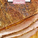 The top of an oven baked beef brisket with some slices cut off of it.