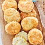 Homemade Popeyes buttermilk biscuits and a cup of melted butter.