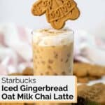 Gingerbread cookie held over a copycat Starbucks iced gingerbread oat milk chai latte.