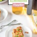 Air fried salmon almondine on a plate and an air fryer behind it.