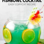 Homemade Bennigan's paddy o' punch fishbowl cocktail on a wood board.