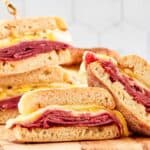 Homemade corned beef breakfast sandwiches on a wood board.