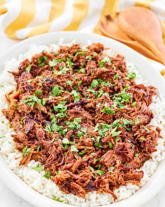 Instant pot pulled pork over rice on a platter.