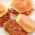 Three cheesy loose meat sandwiches on a dinner plate.