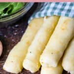 Several homemade Olive Garden breadsticks wrapped in a cloth napkin.