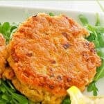 An old-fashioned salmon patty over arugula.
