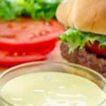 Homemade Smashburger smash sauce in a small glass bowl next to a hamburger.