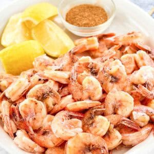 Boiled shrimp served with lemon wedges on a platter.