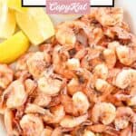 Freshly boiled shrimp and lemon wedges on a a platter.