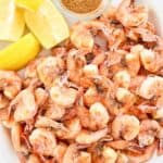 Lemon wedges and freshly boiled shrimp on a platter.