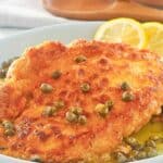 Homemade Buca de Beppo chicken limone topped with capers on a plate.