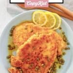 Homemade Buca de Beppo chicken limone, lemon slices, and capers on a plate.