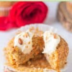 Homemade carrot cake cupcake with cream cheese frosting cut in half.