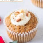 Carrot cupcake with cream cheese frosting on a table.