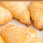 Several homemade Cheddar's honey butter croissants on parchment paper.