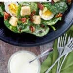 Homemade Commander's Palace salad, a bowl of the dressing, and forks.