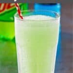 Copycat Taco Bell baja blast freeze drink in a tall glass with a straw in it.