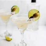 Two homemade Applebee's perfect margaritas garnished with lime and olives.