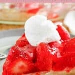 Homemade big boy strawberry pie slice topped with whipped cream.