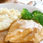 Homemade chicken gravy over chicken served with mashed potatoes and broccoli.