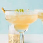 Copycat Chili's presidente margarita and a lime wedge on a coaster.