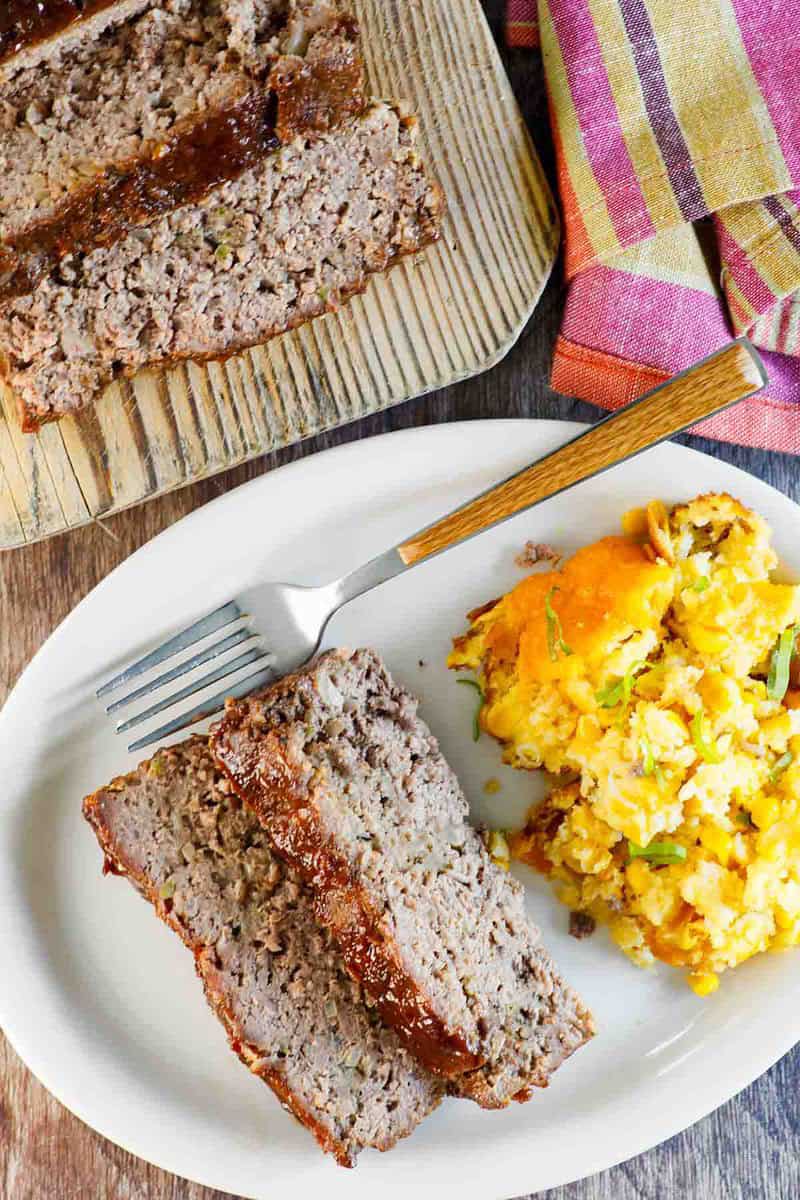 Copycat Cracker Barrel meatloaf slices on a plate and a wood board.