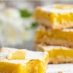 Homemade classic lemon bars and one with a bite out of it.