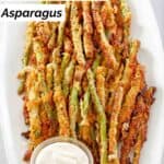 Homemade Longhorn parmesan crusted asparagus and dipping sauce on a platter.
