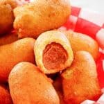 Several homemade mini corn dogs in a serving basket.