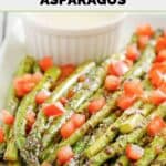 Homemade olive garden parmesan roasted asparagus and a cup of sauce on a plate.