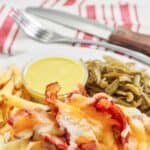 Copycat Outback Steakhouse Alice Springs chicken on a plate with fries and green beans.