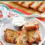 Homemade old-fashioned rhubarb bread and a small cup of butter on a plate.