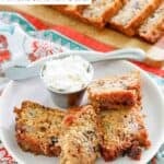 Old-fashioned rhubarb bread slices on a plate and the sliced loaf behind it.