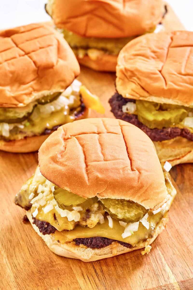 Four copycat double sonic smasher burgers on a wood surface.