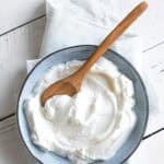 Sweetened yogurt in a bowl on a wood surface.