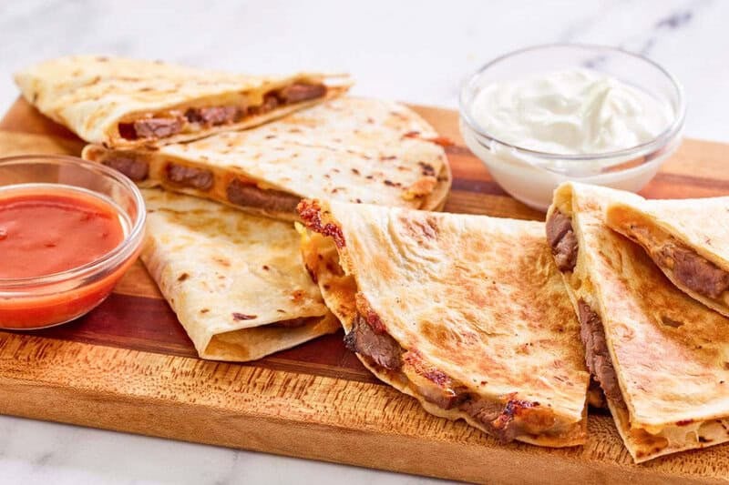 Copycat Taco Bell steak quesadilla served with taco sauce and sour cream.