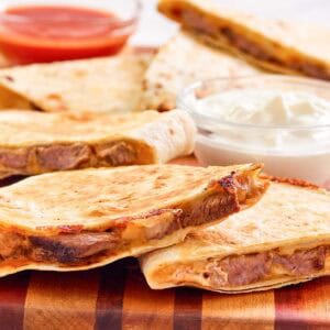 Copycat Taco Bell steak quesadilla on a wood serving board.