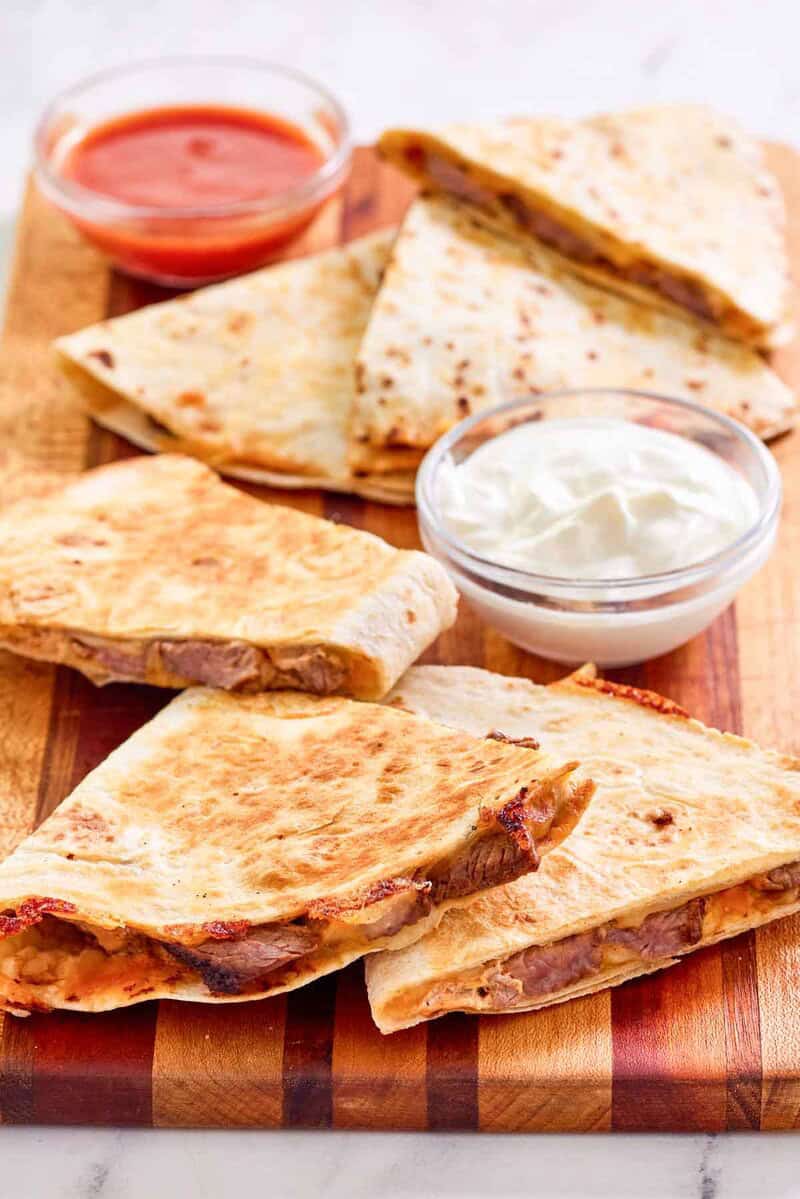 Copycat Taco Bell steak quesadilla, sour cream, and taco sauce.