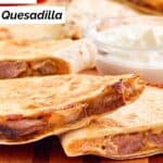 Slices of homemade Taco Bell steak quesadilla on a wood board.