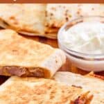 Homemade Taco Bell steak quesadilla slices on a wood surface.