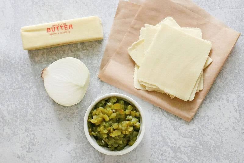 Homemade white queso dip ingredients on a marble surface.