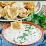 Homemade white queso dip served with scoops tortilla chips.