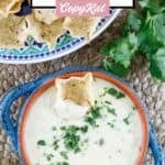 Homemade white queso dip with a scoops tortilla chip in it.