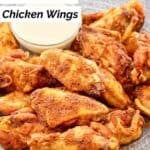 A plate of homemade Wingstop Louisiana rub wings and a cup of dipping sauce.