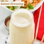 Homemade Applebee's oriental salad dressing in a glass jar and a salad behind it.