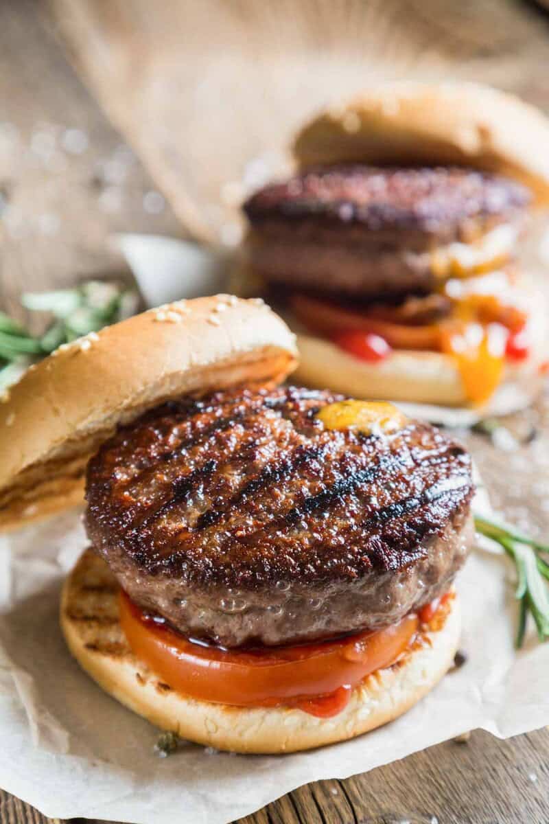 Grilled backyard burgers on parchment paper.